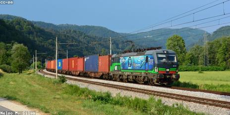 A photograph of a train locomotive and a truck trailer.